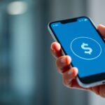 Mano sosteniendo un teléfono con símbolos de dinero.