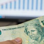 FGTS: Desvendando o Que É, Como Funciona e Quem Tem Direito em 2025 Mão segurando dinheiro do FGTS