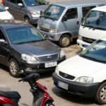 Veículos diversos sob a luz do sol, sugerindo IPVA.