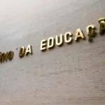 Estudante brasileiro conferindo status do Pé-de-Meia no celular em casa