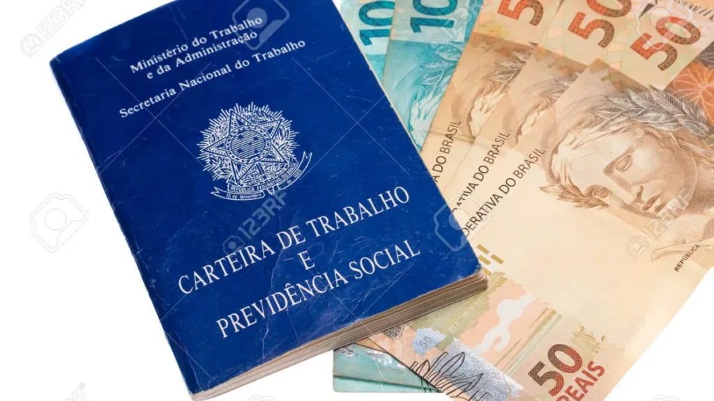 Carteira de trabalho ao lado de dinheiro brasileiro