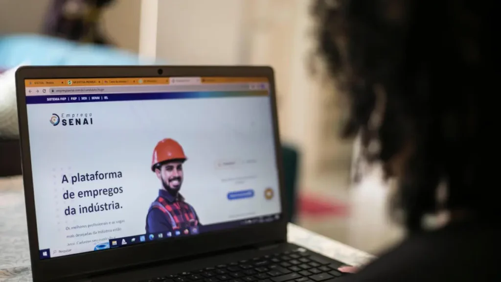 Pessoa procurando emprego em sites de vagas no notebook